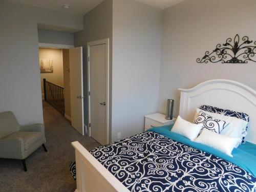 ein Schlafzimmer mit einem großen Bett und einem Stuhl in der Unterkunft 3 Bedroom House #37, Sunalta Downtown in Calgary