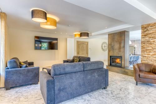 a living room with two blue couches and a fireplace at Le Domaine de Wisbeley in Halet