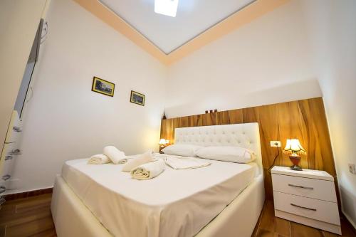 een slaapkamer met een bed met witte lakens en kussens bij THE OLD TOWN CLOCK in Gjirokastër