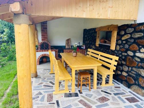 una mesa de madera y sillas en un patio en Casa de vacanță Moțata, en Novaci-Străini