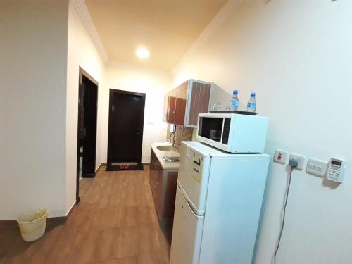 a kitchen with a white refrigerator and a microwave at رانا الخليجية - rana alkhaleejiah in Riyadh Al Khabra