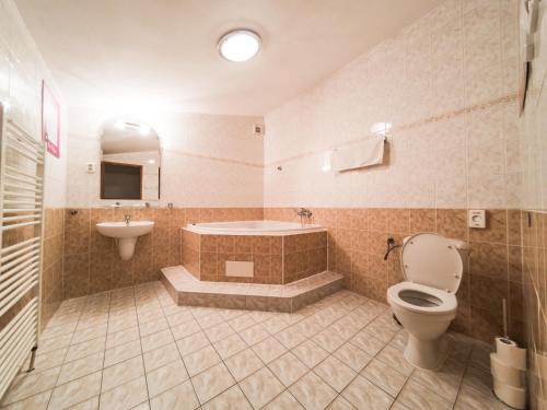 a bathroom with a tub and a toilet and a sink at Penzion Atlas in Liptovský Mikuláš