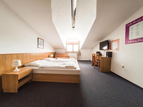 a bedroom with a large bed in a attic at Penzion Atlas in Liptovský Mikuláš