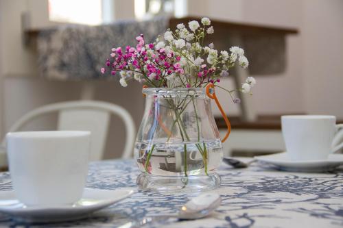 
a vase filled with flowers sitting on a table at Hotel Romantic Los 5 Sentidos in Ciutadella
