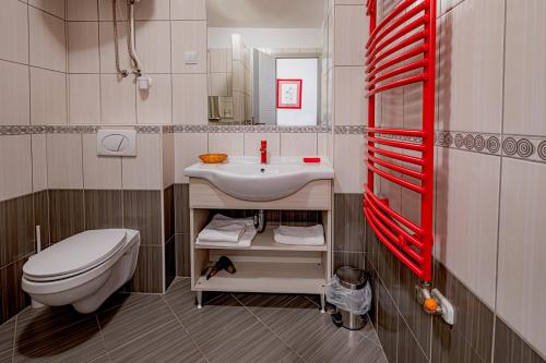 a bathroom with a white sink and a toilet at Riviéra Rooms Vendégszobák in Mosonmagyaróvár