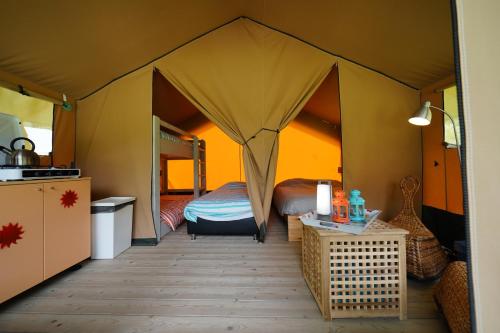 - une chambre avec un lit dans une tente dans l'établissement Safaritent op Camping Berkel, à Bockholtz