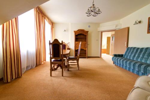 a living room with a couch and a table and chairs at Apartamenty Renesans in Krynica Zdrój