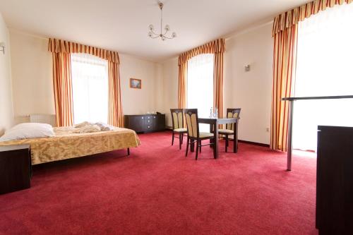 a bedroom with a bed and a table and chairs at Apartamenty Renesans in Krynica Zdrój