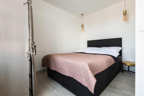 a bedroom with a bed and a shower at Apartament u Rudej in Tolkmicko