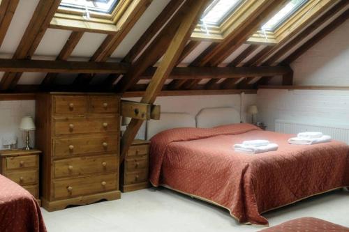 a attic bedroom with two beds and skylights at Brackenborough Hall Coach House - Granary in Louth