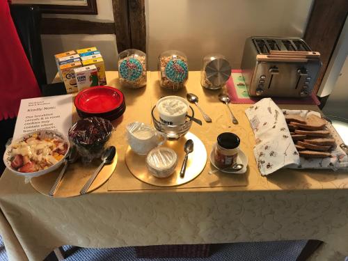 una mesa con comida y otros artículos. en Monkspool B&B, en Church End
