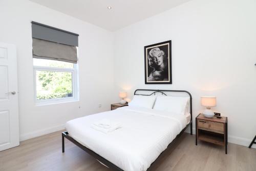 a white bedroom with a bed and a window at Hope House Apartments in Chester