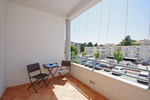 a balcony with a table and chairs and a view of a city at Apartmani Srzic in Makarska