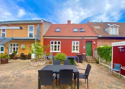 un patio con tavolo, sedie e edifici di Oasen a Viborg