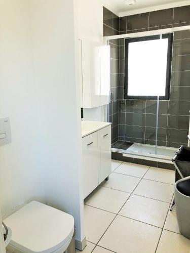 une salle de bain blanche avec toilettes et douche dans l'établissement RESIDENCE 7 maison mitoyenne moderne quartier aiguillon, à Arcachon