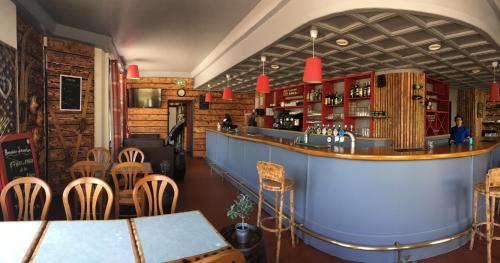 eine Bar in einem Restaurant mit Tischen und Stühlen in der Unterkunft Maison De Savoie in Saint-Pierre-dʼAlbigny