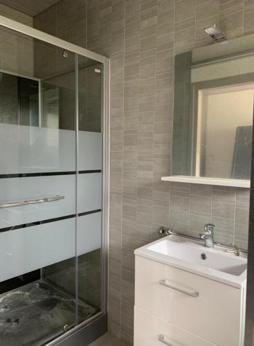 a bathroom with a sink and a glass shower at Camping les Criques de Royan in Saint-Georges-de-Didonne