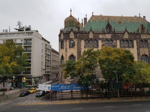 un edificio antiguo con techo verde en una calle de la ciudad en Corvin Museum View Studio en Budapest