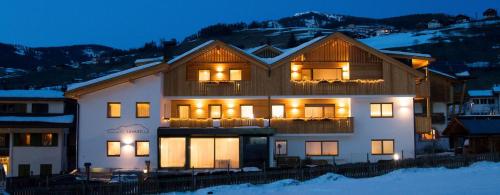a large house in the snow at night at App. Miara - Ciasa Lavarella in San Vigilio Di Marebbe