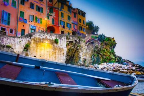 a boat sitting in the water in front of a building at Una Finestra sul Mare - Free Wi -Fi in Riomaggiore