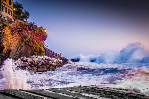 a body of water with waves crashing on a cliff at Una Finestra sul Mare - Free Wi -Fi in Riomaggiore