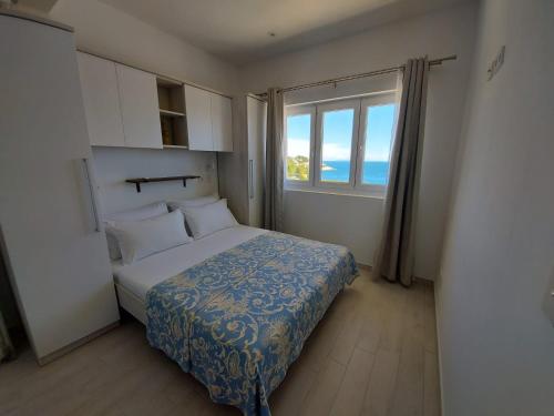 a bedroom with a bed and a large window at Apartments Tanja in Zavalatica