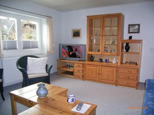 ein Wohnzimmer mit einem TV und einem Holzschrank in der Unterkunft Pension Alte Bäckerei in Kosel in Kosel