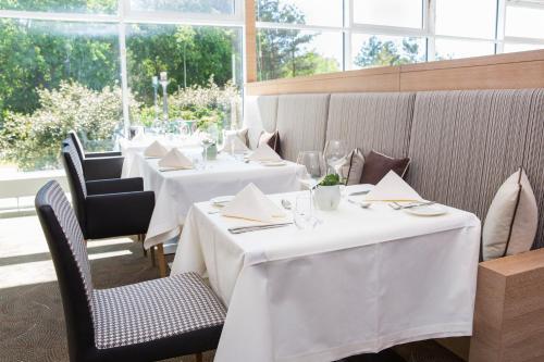 a row of tables in a restaurant with white table cloth at Strandhotel Dünenmeer - Adults only in Dierhagen