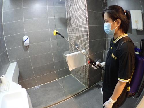 a woman with a mask in a bathroom with a toilet at De Elements Business Hotel Damansara in Damansara Perdana