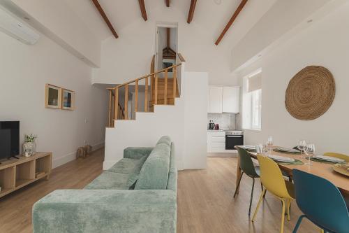a living room with a green couch and a table at Vibrant Host - Heroismo's Metro in Porto