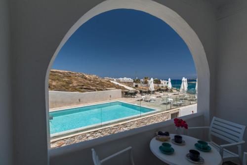 a room with a view of a pool and the ocean at Adonis Hotel Studios & Apartments in Naousa