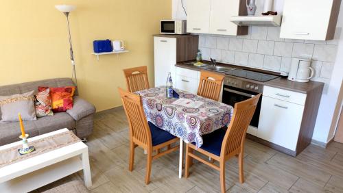 een woonkamer met een tafel en stoelen en een keuken bij Sylvias Ferienwohnung Nr6 souterrain in Görlitz