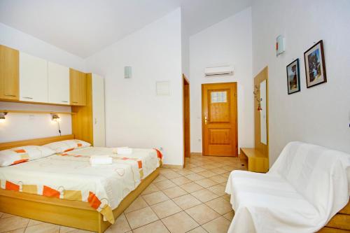 a bedroom with a bed and a chair in it at Apartmani Srzic in Makarska