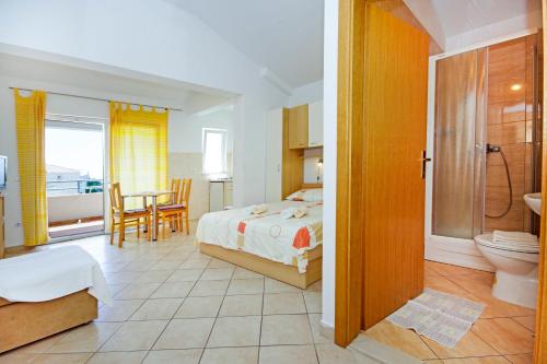 a bedroom with a bed and a bathroom at Apartmani Srzic in Makarska