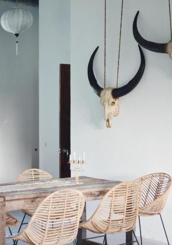 a dining room with a table with horns on the wall at Lambo Homestay in Waikabubak