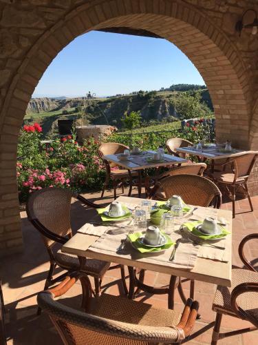 een patio met tafels, stoelen en bloemen bij Agriturismo Podere Marcampo in Volterra