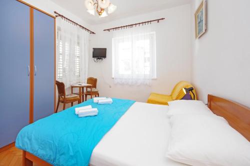 a bedroom with a large bed with a blue blanket at Apartmani Srzic in Makarska