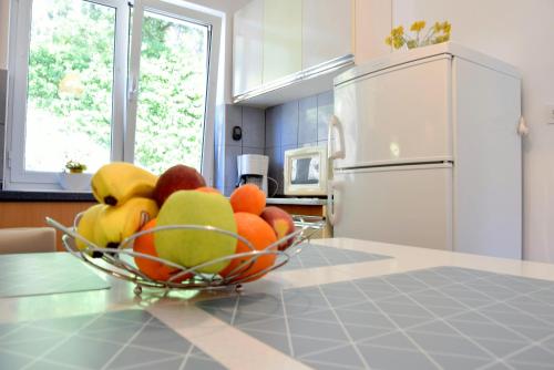 a bowl of fruit on a counter in a kitchen at Rab City Apartment Greeny in Rab