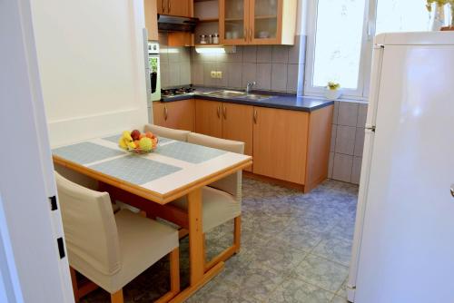 a kitchen with a table with a bowl of fruit on it at Rab City Apartment Greeny in Rab