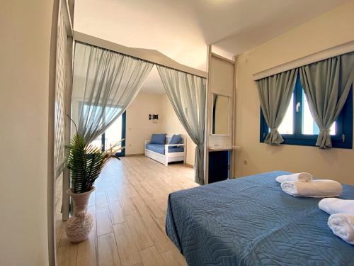 ein Schlafzimmer mit einem blauen Bett und einer Topfpflanze in der Unterkunft Michail Suites Afiartis Karpathos in Karpathos
