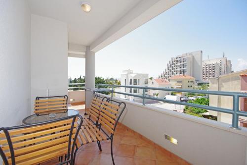a balcony with two chairs and a table on it at Apartmani Srzic in Makarska