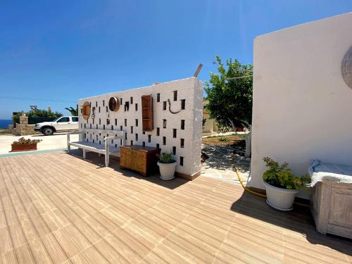 a building with a bench on a wooden deck at Michail Suites Afiartis Karpathos in Karpathos Town