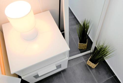 a white table with a mirror and two plants at Rab City Apartment Greeny in Rab
