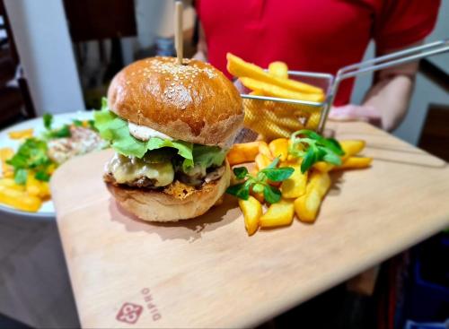 a sandwich and french fries on a cutting board at Penzion Troja in Lipany