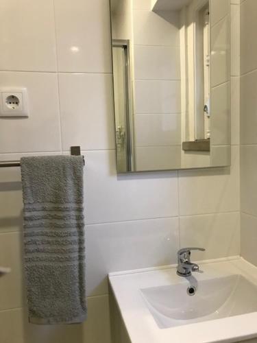 a bathroom with a sink and a mirror and a towel at Romantic 1 Bedroom Apartment at Roma Avenue - 1C in Lisbon
