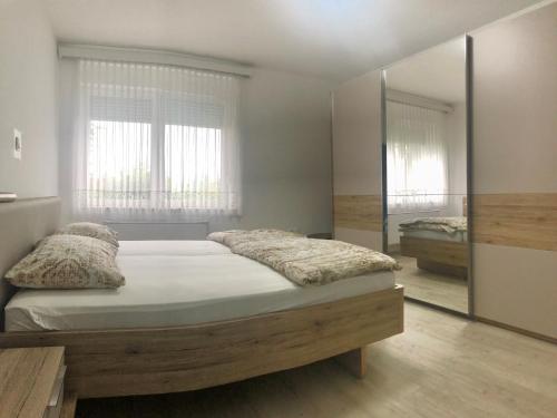 1 dormitorio con cama y espejo grande en Apartments Andrej, en Ptuj