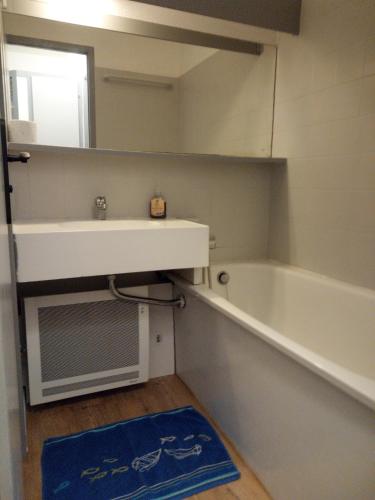 une salle de bain avec un lavabo, une baignoire et un miroir dans l'établissement Studio cabine Arzon Crouesty 4p, à Arzon