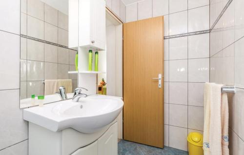 a white bathroom with a sink and a shower at Apartments Franelli in Brseč