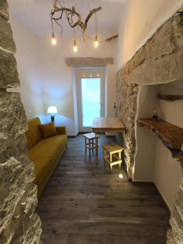 salon z kanapą i kamiennym kominkiem w obiekcie B&B François le cordonnier maison de charme w mieście Santa Teresa Gallura