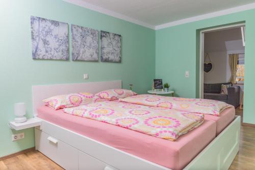een slaapkamer met een roze bed met roze kussens bij Ferienwohnung s' Plätzli in Freiamt